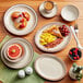 A table set with Acopa brown speckle narrow rim stoneware plates and food.