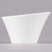 A white Arcoroc Ludico deep bowl on a gray surface.