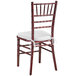 A Lancaster Table & Seating mahogany Chiavari chair with a white cushion.