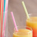 Two glasses of orange juice with Choice jumbo neon straws.
