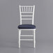 A white Lancaster Table & Seating Chiavari chair with a navy blue cushion.
