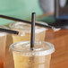 A group of plastic cups with Choice giant black straws.