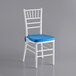 A Lancaster Table & Seating white wood Chiavari chair with a blue cushion.