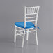 A white Lancaster Table & Seating Chiavari chair with a blue cushion.