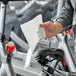 A man cleaning a bicycle seat with a Choice sports towel.