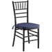 A Lancaster Table & Seating black wood Chiavari chair with navy blue cushion.