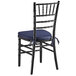A Lancaster Table & Seating black wood chiavari chair with a navy blue cushion.
