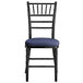 A Lancaster Table & Seating black wood chiavari chair with navy blue cushion.