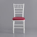A white Lancaster Table & Seating Chiavari chair with a wine red cushion.