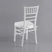 A Lancaster Table & Seating white wood Chiavari chair with a white seat cushion.