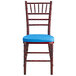 A Lancaster Table & Seating Mahogany Wood Chiavari chair with a blue cushion.