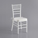 A white Lancaster Table & Seating Chiavari chair with ivory cushion.