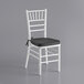 A Lancaster Table & Seating white wood Chiavari chair with a black cushion.