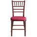 A Lancaster Table & Seating mahogany Chiavari chair with a wine red cushion.