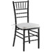 A black Lancaster Table & Seating Chiavari chair with ivory cushion.