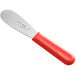 A Choice stainless steel sandwich spreader with a red scalloped edge and handle.