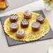 A plate of chocolate desserts on a gold foil lace doily.