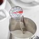 A close-up of a CDN ProAccurate frothing thermometer in milk.