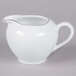 A white porcelain creamer with a silver rim and handle.