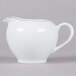 A white pitcher with a silver handle.