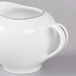 A white porcelain pitcher with a silver handle.
