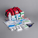 A red Medique Large Trauma First Aid Kit bag filled with medical supplies.