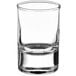 A close-up of a Pasabahce clear glass shot glass with a small rim.