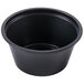 A Dart black plastic souffle cup on a white background.