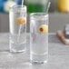 Two Pasabahce tall shot glasses with liquid and olives.