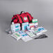 A red Medique trauma first aid kit with medical supplies.