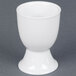 A CAC white China egg cup on a gray surface.