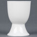 A close-up of a white CAC China egg cup.