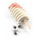 A Silikomart Tango ice cream cake pop with white and pink frosting on a popsicle stick with coffee beans.