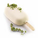 A white ice cream bar with green pieces of food on top in a Silikomart Mini Classic Ice Cream Baking Mold.