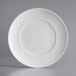 An Acopa Liana bright white porcelain plate with an embossed circular pattern on the rim.