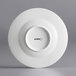 An Acopa Liana white porcelain saucer with embossed lines.