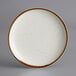 An Acopa Keystone Vanilla Bean stoneware coupe plate with brown specks.