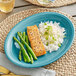 An Acopa Capri Caribbean turquoise stoneware platter with asparagus, salmon, and rice on a table.