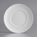A close up of an Acopa Liana bright white porcelain plate with embossed lines on the rim.