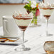 Two Acopa Radiance martini glasses with a dessert and drink in them.