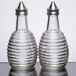 A close-up of Tablecraft beehive oil and vinegar dispensers with stainless steel tops.