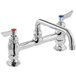 A close-up of a Waterloo chrome deck-mounted faucet with two red handles.