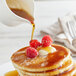 A stack of Butternut Mountain Farm pancakes with syrup and raspberries.