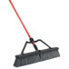 A Libman rough surface heavy-duty push broom with a red handle.
