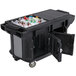 A black Cambro Versa Ultra work table with a large cooler filled with bottles on it.