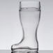 A close-up of a Stolzle beer boot glass with beer in it on a table.
