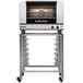 A silver and black Moffat electric convection oven on wheels with two racks.