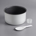 A white and black pot with a white plastic spoon inside.