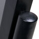 A close-up of a black metal post on an Aarco double pedestal poster stand.
