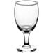A close-up of a clear Acopa wine glass with a small base.